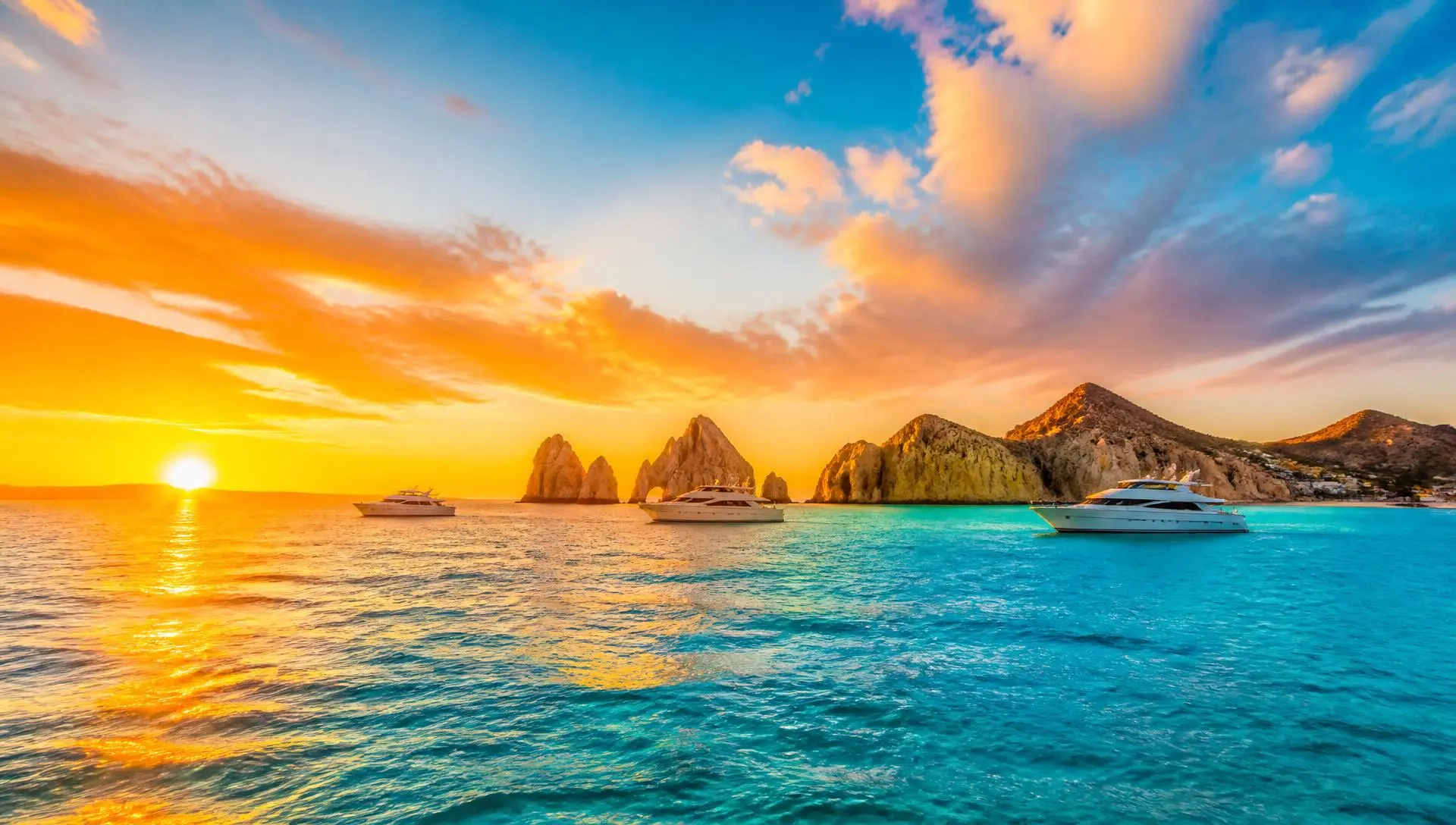 Vivid Cabo San Lucas sunset over turquoise water with iconic rock formations, luxury yachts, and golden Love Island style sunlight